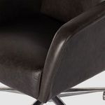 Close-up on black leather upholstery texture and stitching along armrest