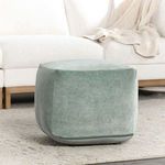 Green velvet pouf placed in living room setting on rug near white sectional sofa