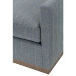 Close-up of rounded armrest edge with striped upholstery and cushioned seat gap