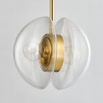 Close-up of clear glass hemispheres and aged brass center showing bulb detail against gray wall