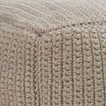 Close-up of densely knitted taupe fabric texture and stitching detail on pouf