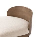Close-up of curved wood backrest detailing and fabric upholstery edge
