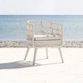 Dana Rope Dining Chair shown in outdoor coastal setting with sea and sand background