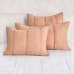Three taupe beige shams styled on white bed, showing size and decorative use