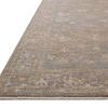 Side angle showing low pile height and subtle border pattern of the Louisa Stone Multi Rug.