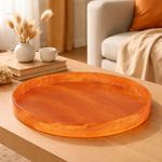Orange resin tray styled on wooden table in a cozy living room with neutral decor accents