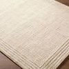 Close-up angled view highlighting the wool texture and layered border on Benchcraft Sand Handmade Rug.