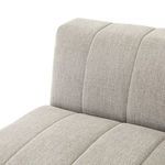 Angled close-up of tubular vertical channels on sandstone upholstered armrest and seat