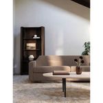 Finch Sofa styled in a light room with rug, coffee table, and dark wood round bookcase