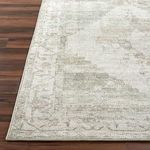 Edge close-up of Luca Olive rug showing border pattern and machine woven finish on hardwood floor
