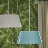 Two Mirasol pendants hanging in room with tropical leaf wallpaper, one white and one sky blue shade