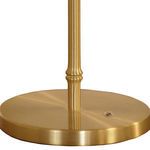 Close-up of round brass lamp base with slender stem rising from center