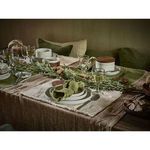 Rustic dining table styled with Frivole placemats and matching green napkins, glassware, and natural decor