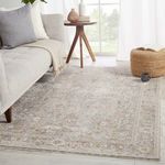 Living room setting with rug spread beneath sofa and table near bright window