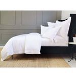 Side angle of white Sheena Bamboo Sateen Duvet Set showing bed frame legs and paneled gray wall in background