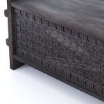 Close-up of carved geometric design on corner section of trunk's front panel