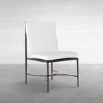 Outdoor side chair with white cushions and wrought aluminum frame featuring subtle gold accents on finials