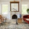 Similar living room view of Margot rug showing more of rug pattern and fireplace reflection in mirror