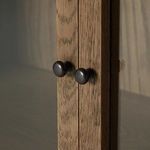 Angled close-up of edge and hinge of cabinet glass door showcasing frame detail