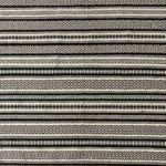 Top-down view focused on the intricate black and white diamond and stripe pattern of the rug
