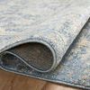 Close-up of rug corner rolled up, revealing soft polyester texture and backing