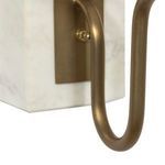 Close-up of curved bronze arm of Calla Bookshelf Lamp with toggle switch on marble base