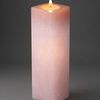 Close-up of tall pink alabaster T-Lite holder with soft candlelight glow inside