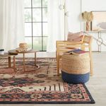 Top-down view showing round coffee tables on rug detailed with books and decorative garland
