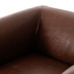 Interior corner of rounded arm and cushioned backrest with smooth leather texture