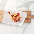 Top view showing light wood tone plank with sliced citrus fruits on parchment paper