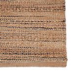 Close-up detail of solid tan rug variant showing mixed yarns and navy flecks in weave