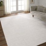 Ivory rug placed in white wall room with a modern sofa showing scale and proportion on wood flooring