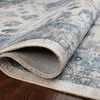 Rolled corner of rug lifted to expose woven polyester backing and rug thickness