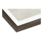 Close-up corner of dark wood frame with white matte border and subtle textured brushstrokes on the print