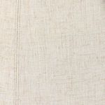 Close-up of cream linen fabric texture with visible stitching and fine weave