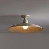Flush mount ceiling light illuminated in a room with visible wall and ceiling background