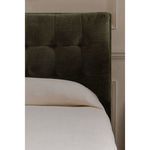 Front view of Sebastion Storage Bed in a furnished room with framed art and table lamps