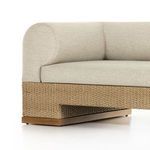close-up side angled view showing woven wicker base with wood trim and beige fabric cushions