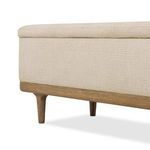 Close-up angled view focusing on fabric upholstery and oak base corner