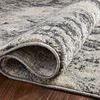 Side view close-up highlighting woven texture and backing of Austen Stone Pebble rug on wood floor