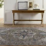 Rug in front of a wood console table with artwork and accessories in a room with light walls