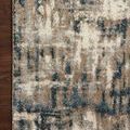 Corner detail of Spirit Stone Blue Rug on dark wood floor showing pattern and neat edge stitching