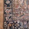 Close-up of the rug’s corner with intricate patterned border and terracotta details on hardwood floor