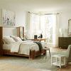 Atlas Bed styled in bright bedroom with green accents and large windows, showing full room context