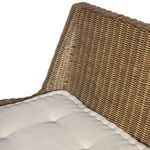 Side view focusing on tight rattan weave and plush beige cushion