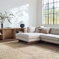 Rug shown in a sunlit modern living room under a light beige sectional sofa with wooden beams and window
