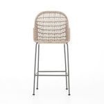 Bar stool with white wicker back and seat, supported by slim bronzed iron legs