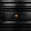 Close-up detail of one drawer front with brass round pull and beveled edging