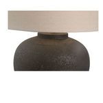 Close-up of lamp neck and bottom edge where beige fabric shade meets textured base