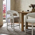 Styled in a natural light dining room by a wood table, showing two stools on a neutral rug.